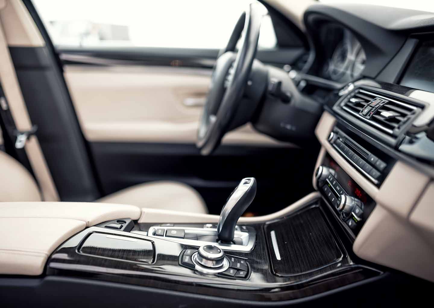 Kunststoffe in der Automobilindustrie: Innenansicht eines modernen Luxusklassewagens mit schwarzem und beigefarbenem Interior.